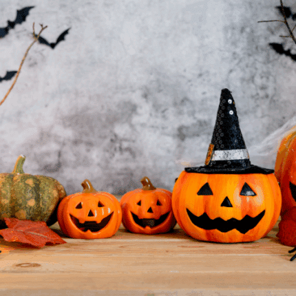 Διακοσμητικές κολοκύθες Halloween σε ξύλινο τραπέζι, με νυχτερίδες και φύλλα, ιδανικές για DIY φθινοπωρινές και spooky κατασκευές.